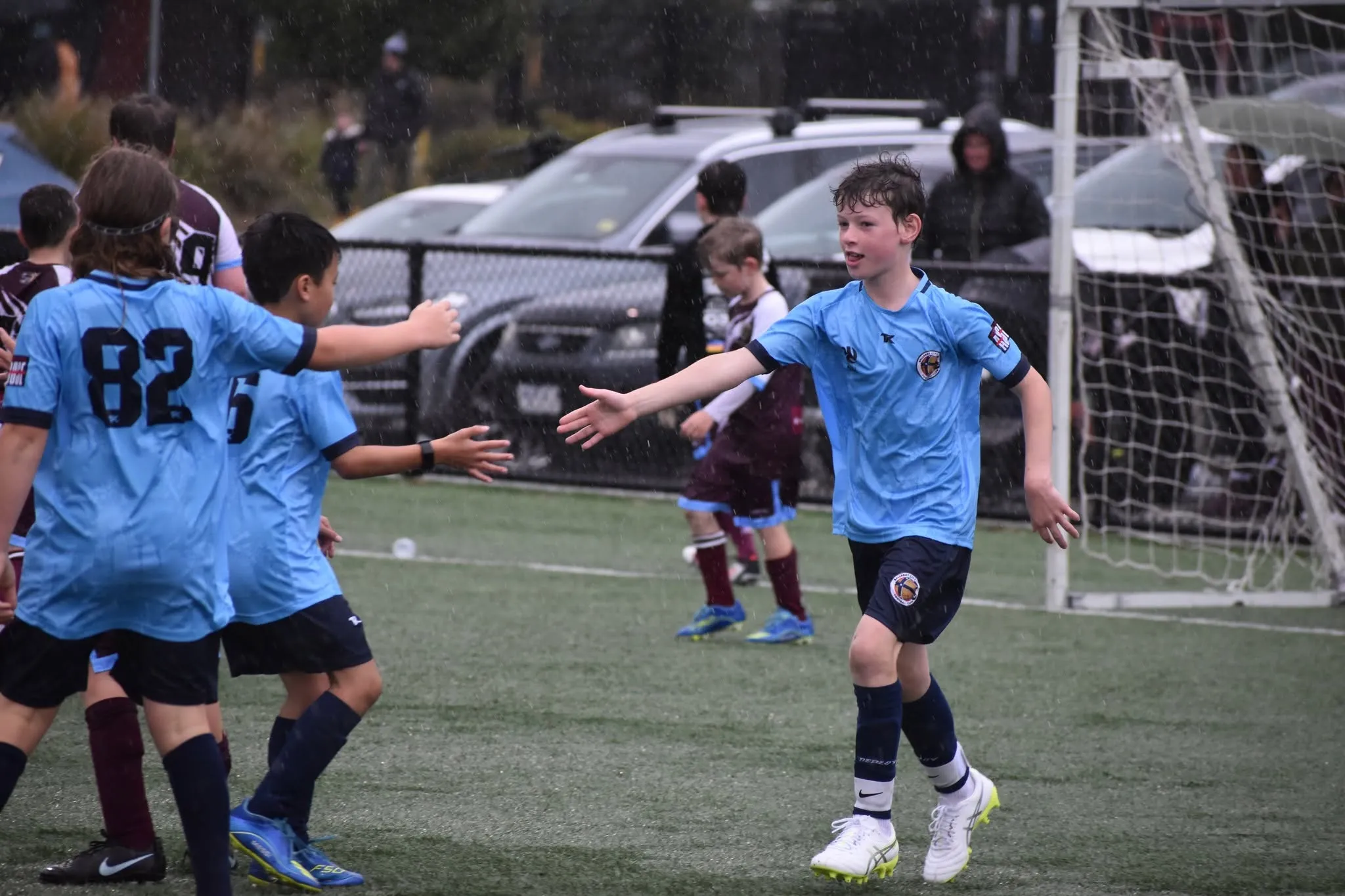 Ballarat City juniors celebrating a goal in the rain